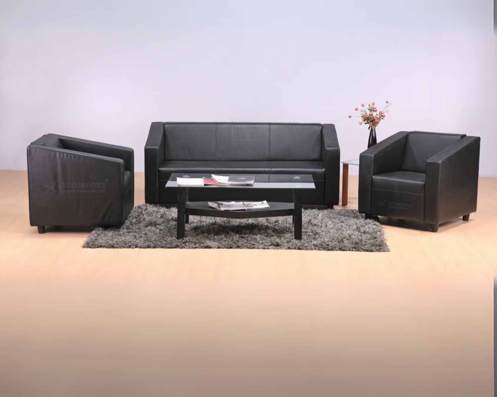 Modern black leather sofa set with matching armchair and coffee table