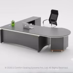 Modern grey curved executive office desk with integrated storage, laptop, office chair, and minimalist plant decoration.