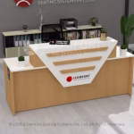 Modern wooden reception desk with white geometric front panel, Scomfort branding, storage shelves, printer, and indoor plants.