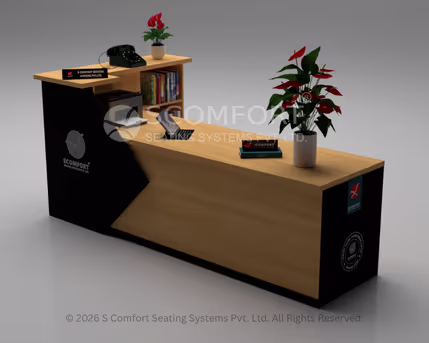 A modern reception desk featuring a light wood finish with striking black geometric panels, a raised counter section on the left, built-in shelving, and decorated with red flowering plants.